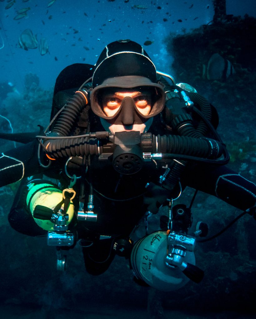 Underwater portrait of technical diver using a rebreather device to locate shipwreck, Lombok, Indonesia