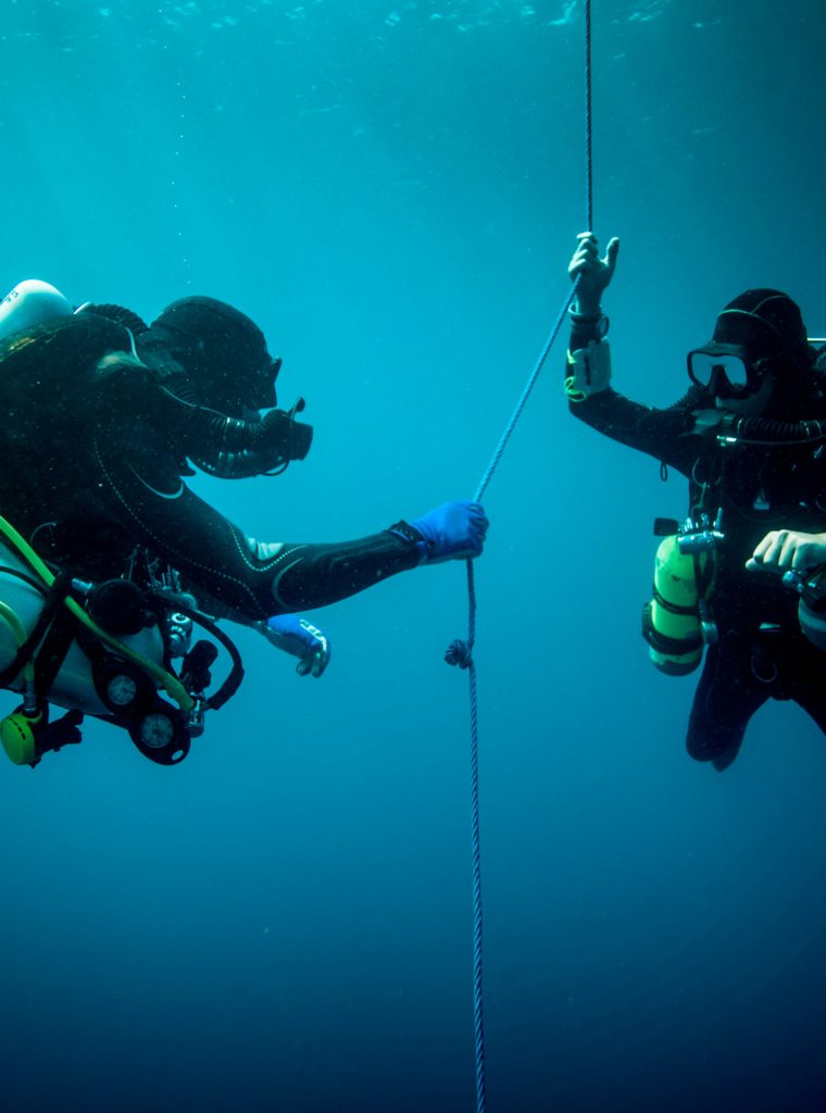 Underwater view of two technical divers using rebreathers device to locate shipwreck, Lombok, Indonesia